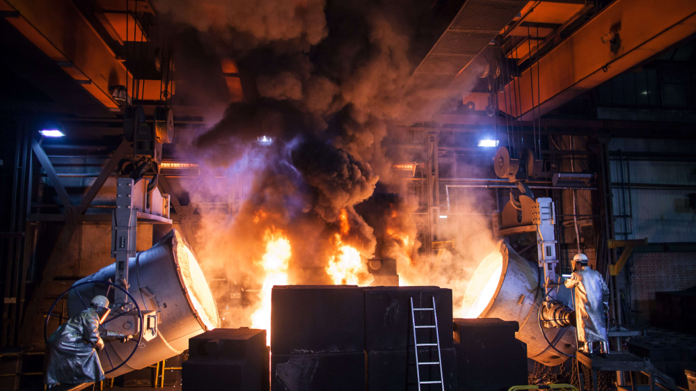 inside an iron casting factory with fire and smoke